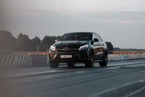 Zwarte Mercedes op de weg bij schemering